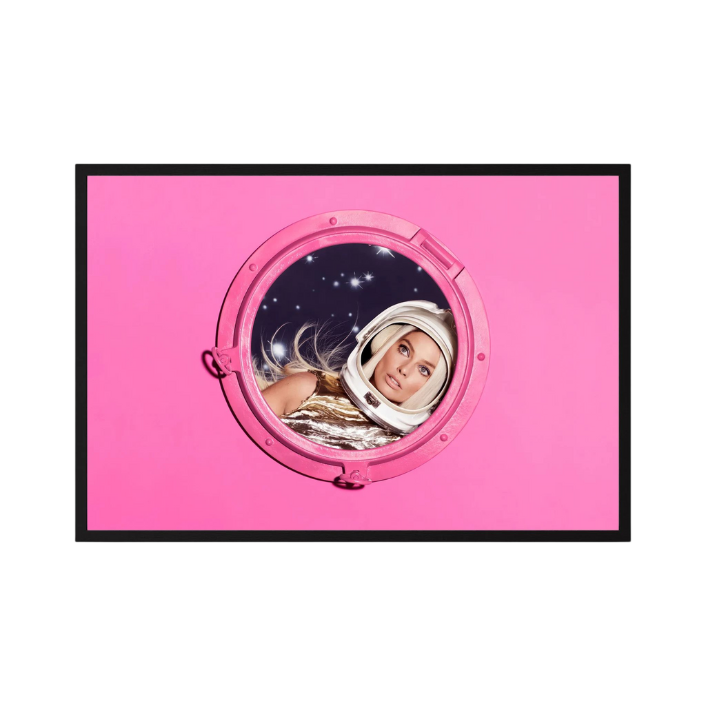 Woman in a metallic astronaut suit looks through a circular porthole set in a vivid pink field, shown in product view 2.