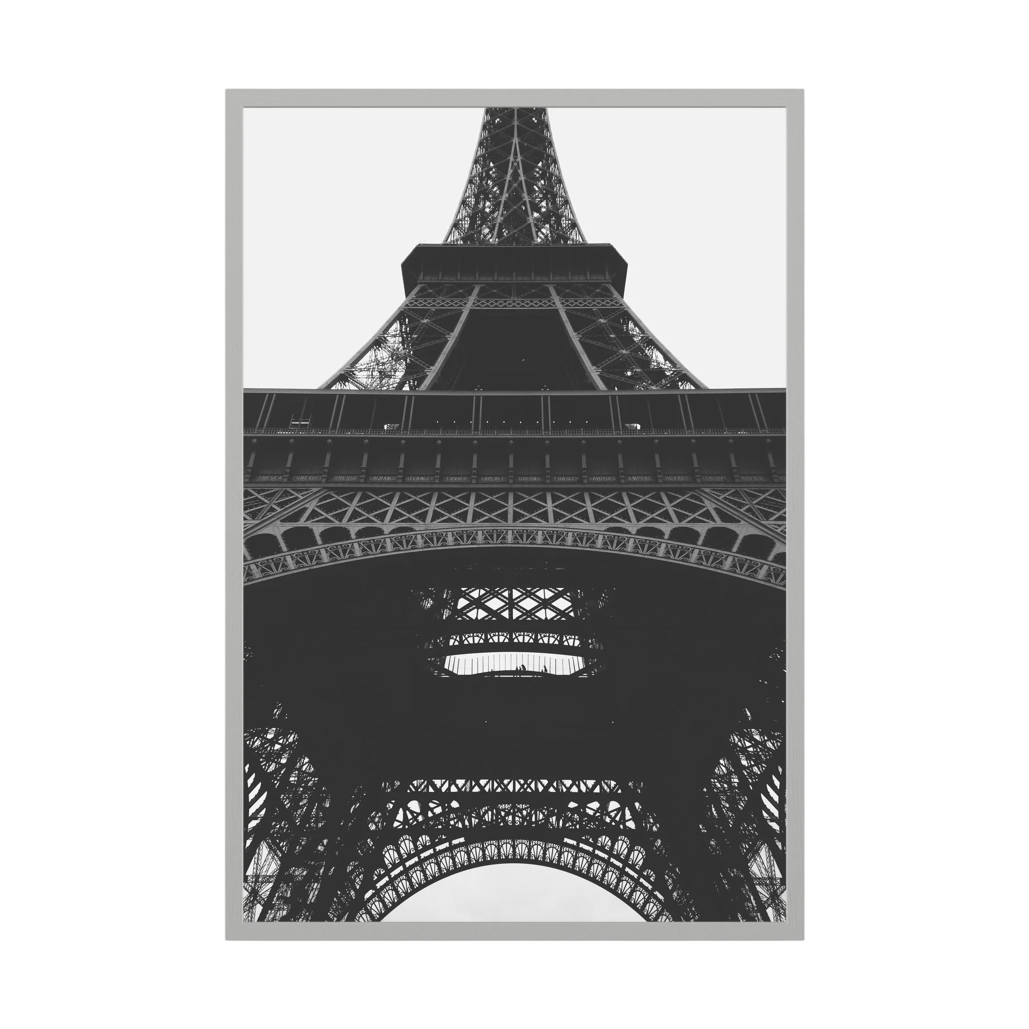 Black and white view looking upward through the iron structure of the Eiffel Tower.